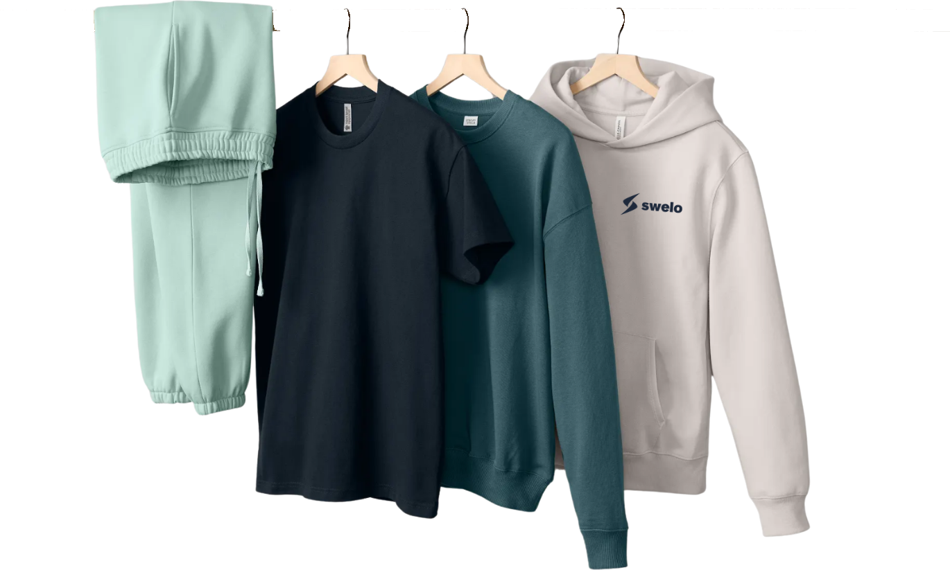 Mint sweatpants, navy short-sleeve tee, teal crewneck sweatshirt, and a cream Swelo hoodie hanging on a wooden rack